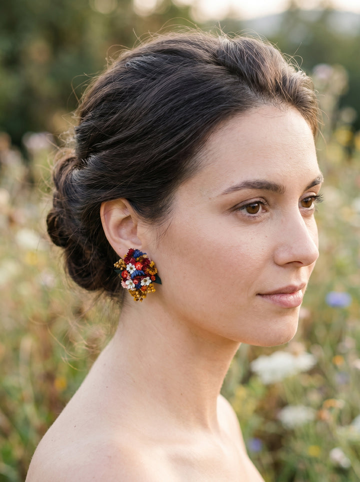 Woman with styled hair and colorful earrings against a natural background