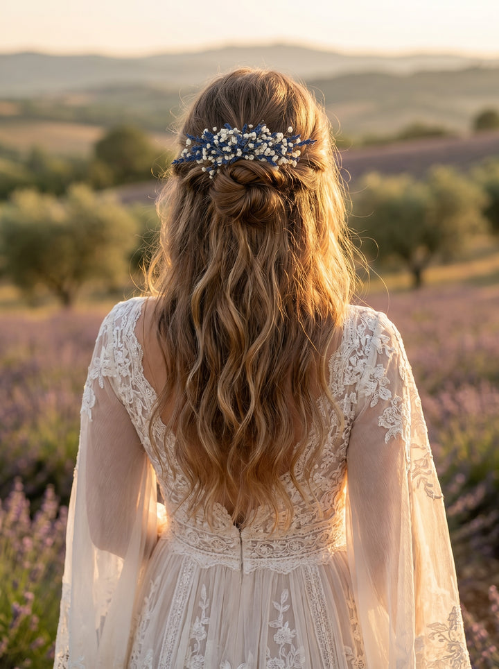 Woman with long hair wearing a floral hair comb in a scenic outdoor setting.