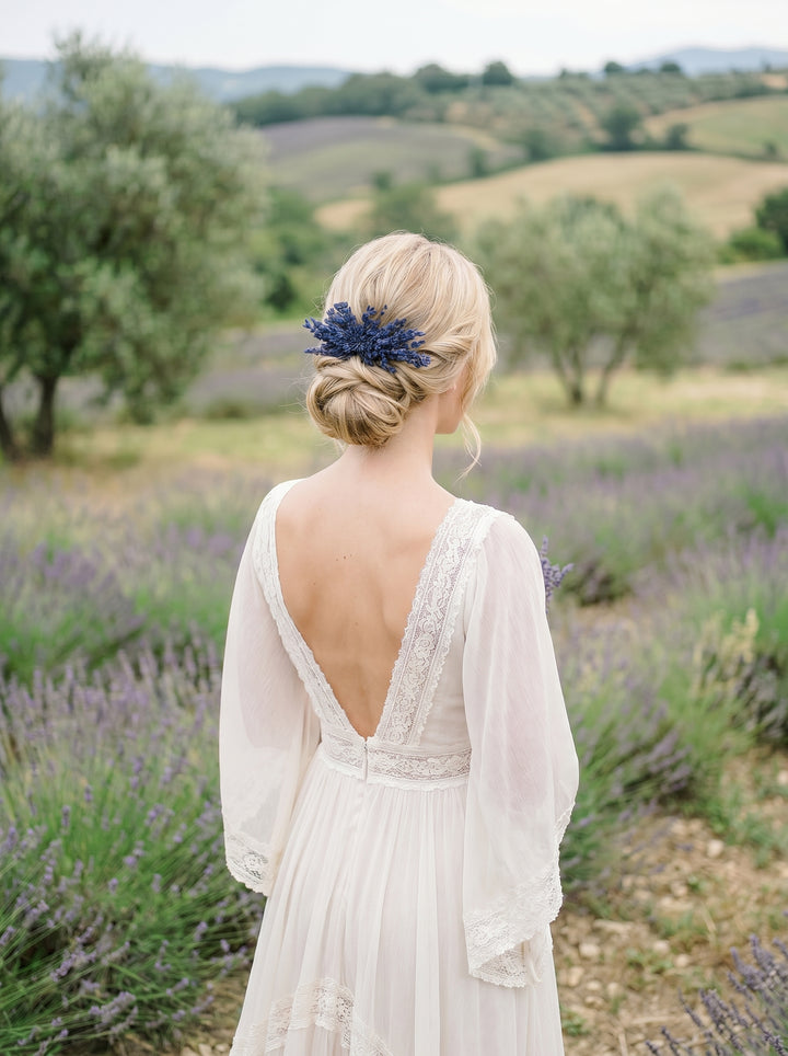 Woman in a white dress with an open back standing in a lavender field.