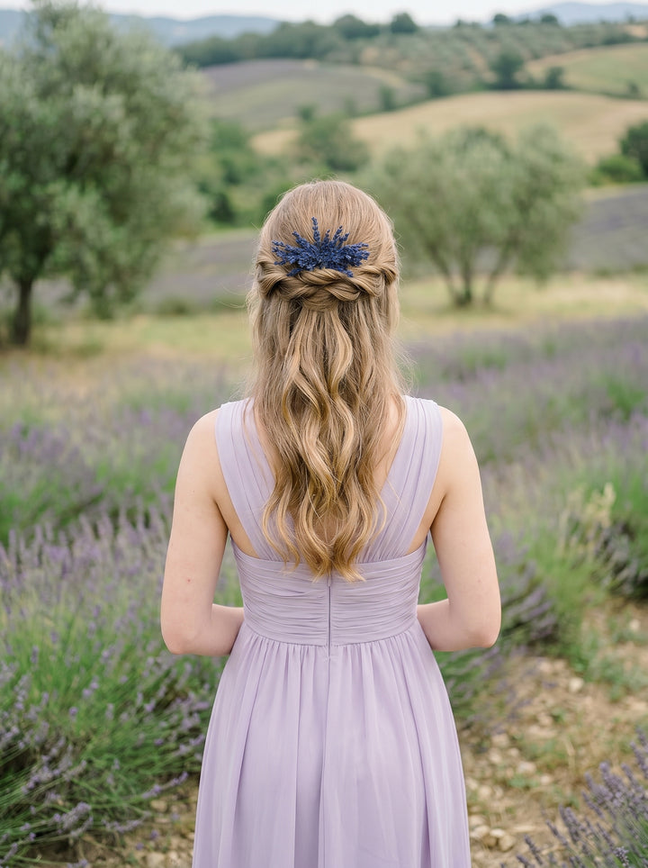 Woman in a lavender dress with a floral headpiece standing in a field of lavender.