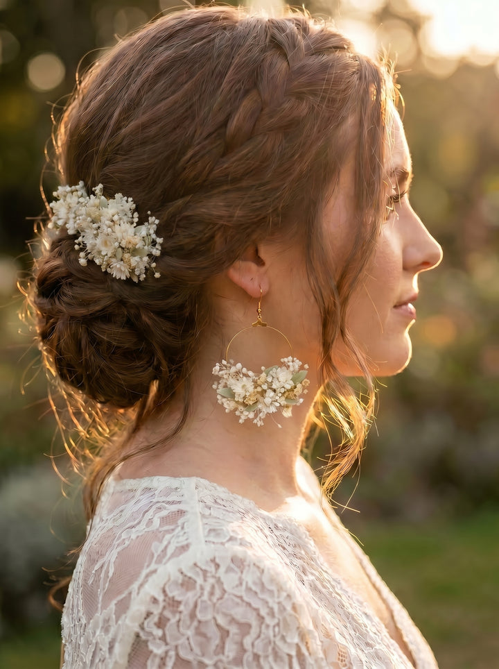 Bride with braided hair and floral accessories - hair comb and earring  in a natural setting