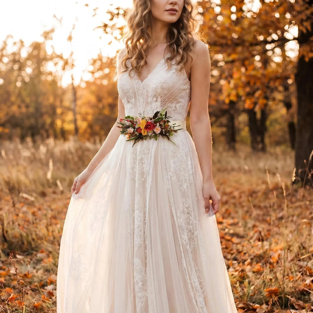Woman in a white lace dress with floral boho belt in an autumn setting.
