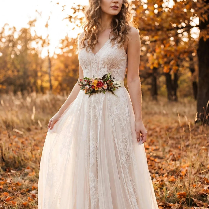 Woman in a white lace dress with floral boho belt in an autumn setting.