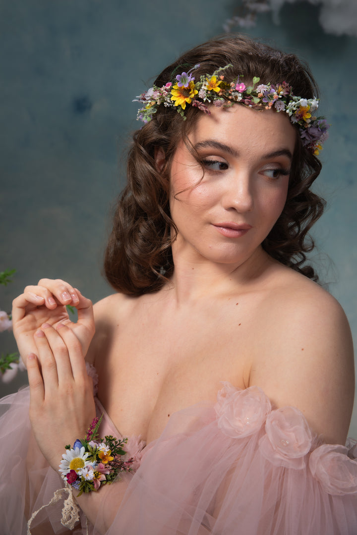 Woman wearing a floral headband and bracelet against a textured blue background