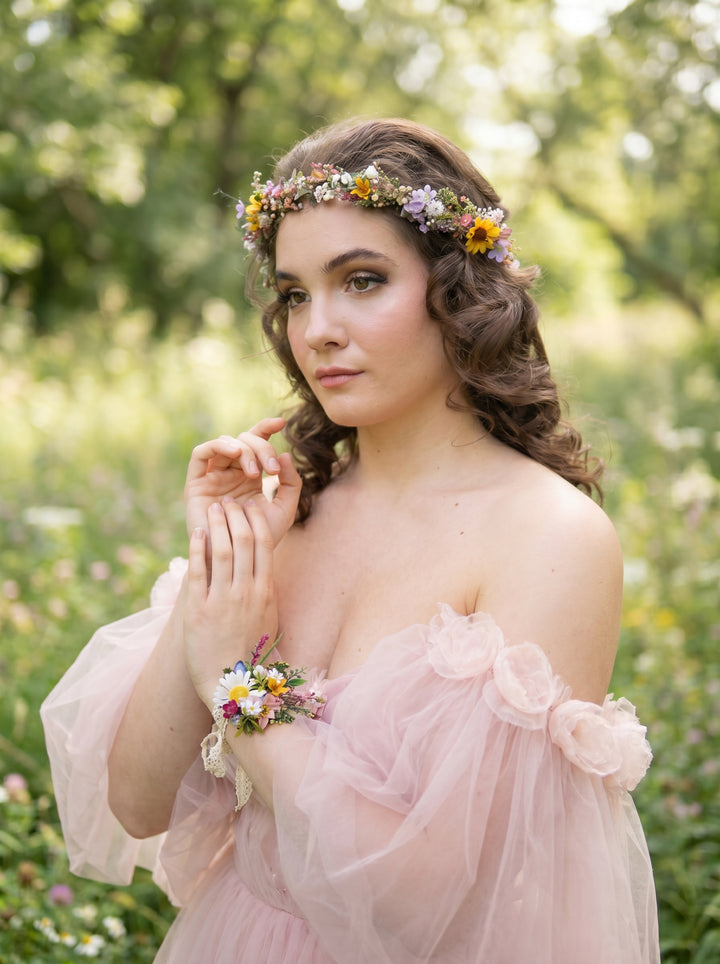 Woman in a pink dress with  wild floral accessories in a natural setting