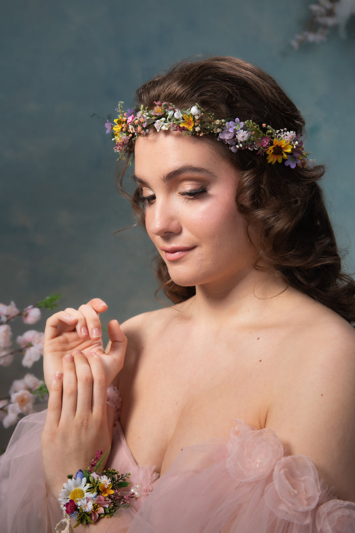 Woman wearing a floral crown and bracelet against a floral background