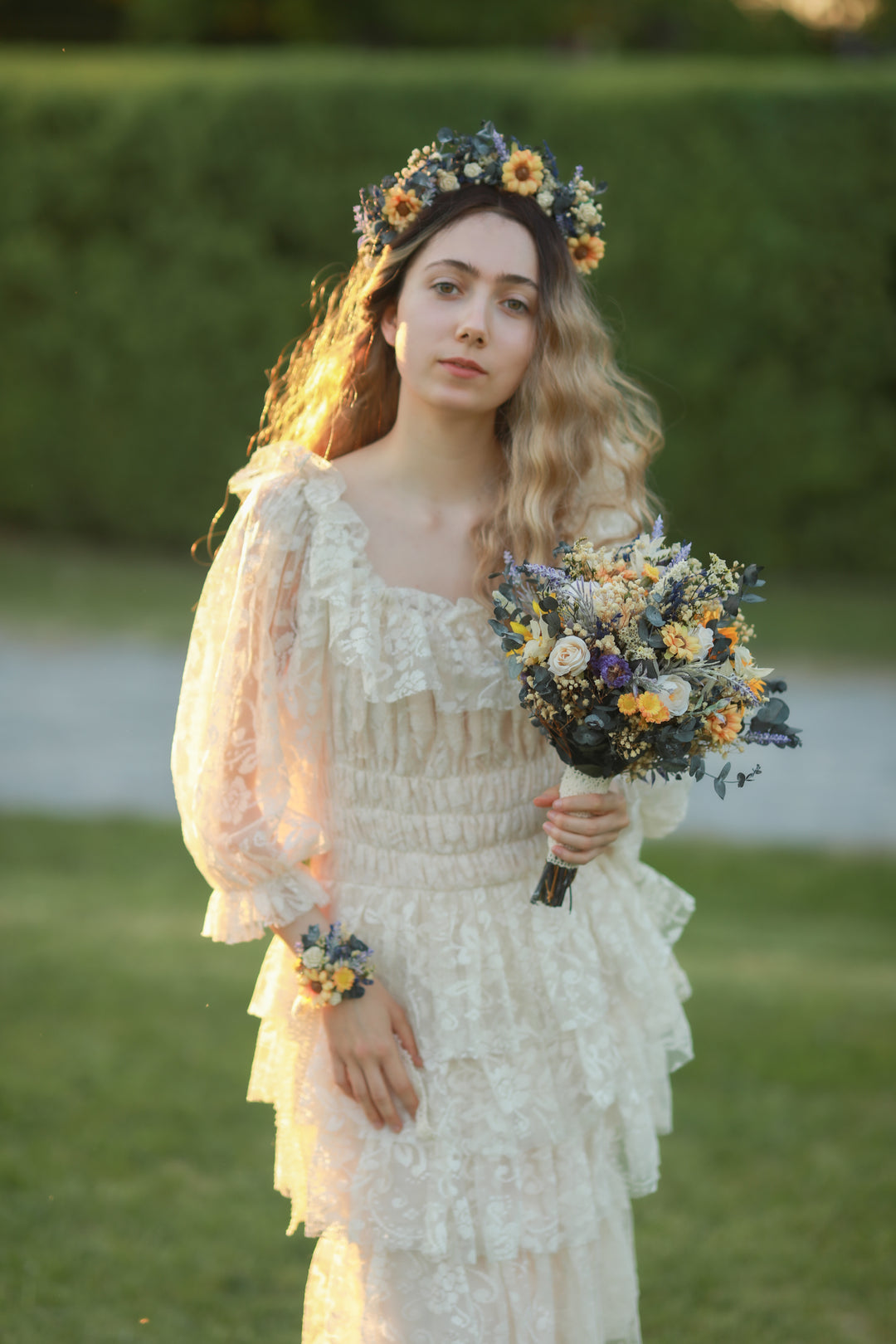 Woman in a white dress holding a bouquet of flowers outdoors