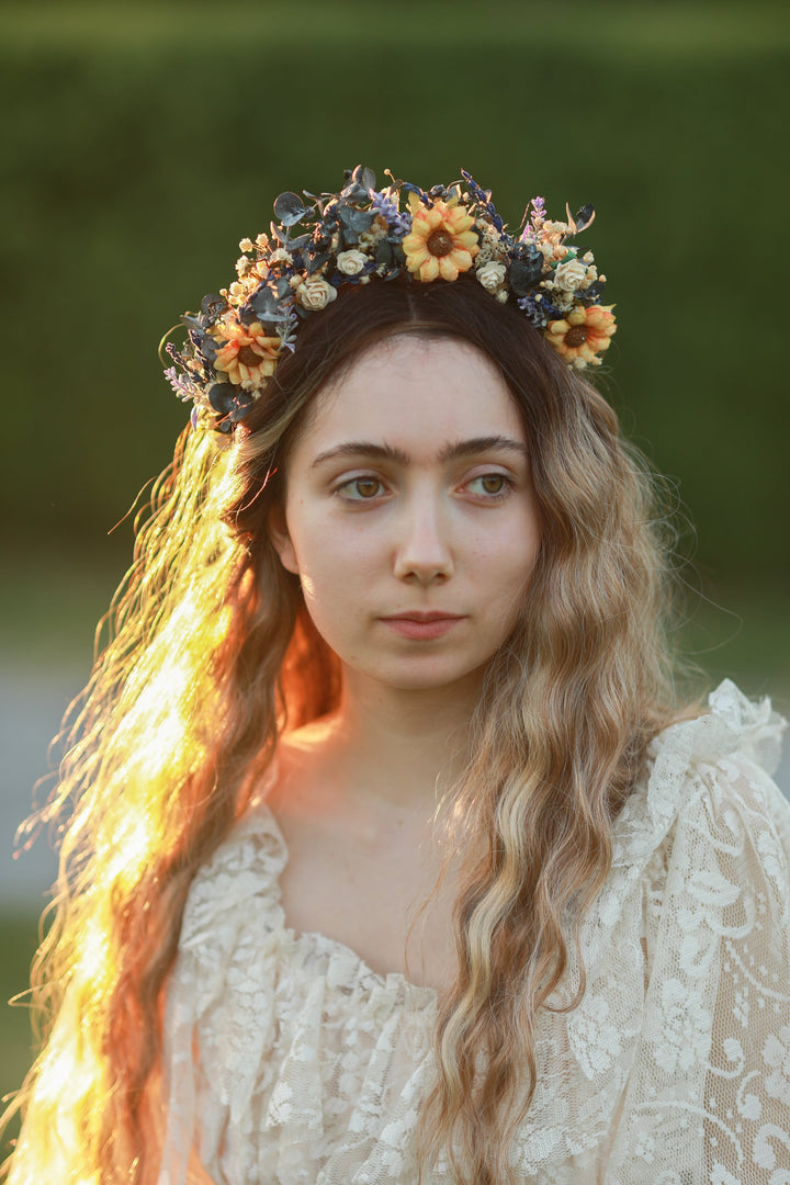 Woman wearing a floral sunflower crown with a blurred green background