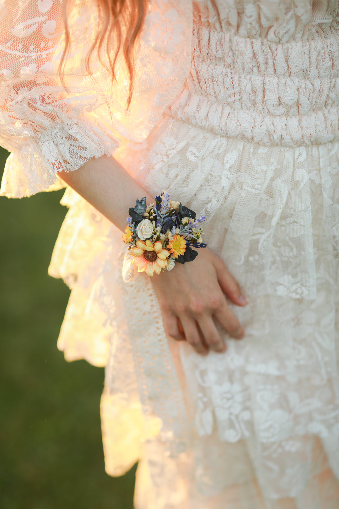 Person wearing a floral wrist corsage with a blurred background