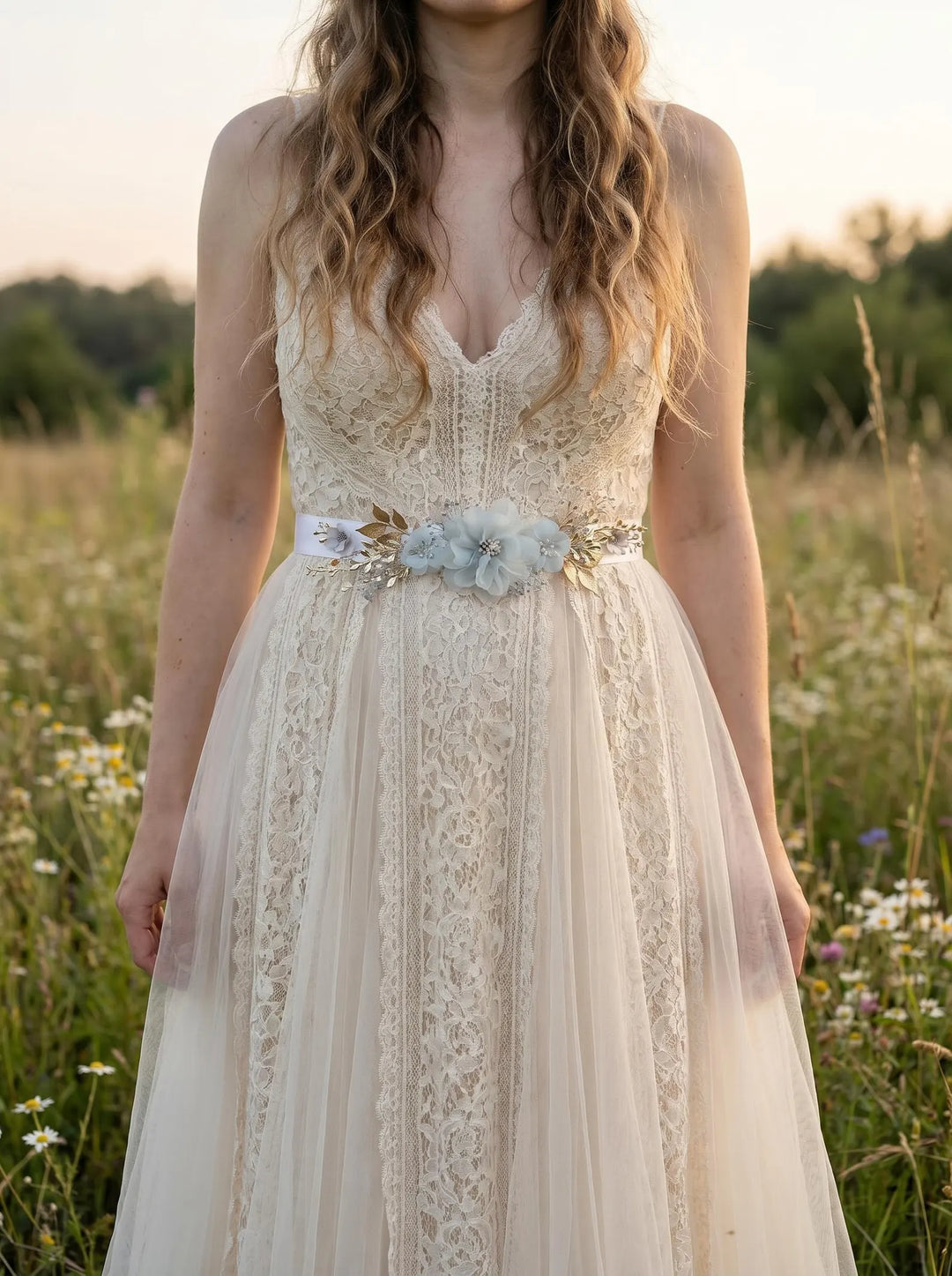 Woman wearing a lace dress with a floral belt in a field