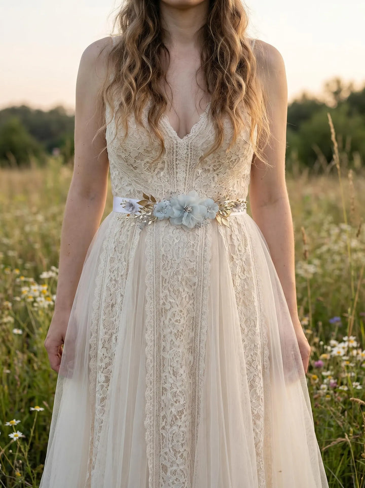 Woman wearing a lace dress with a floral belt in a field