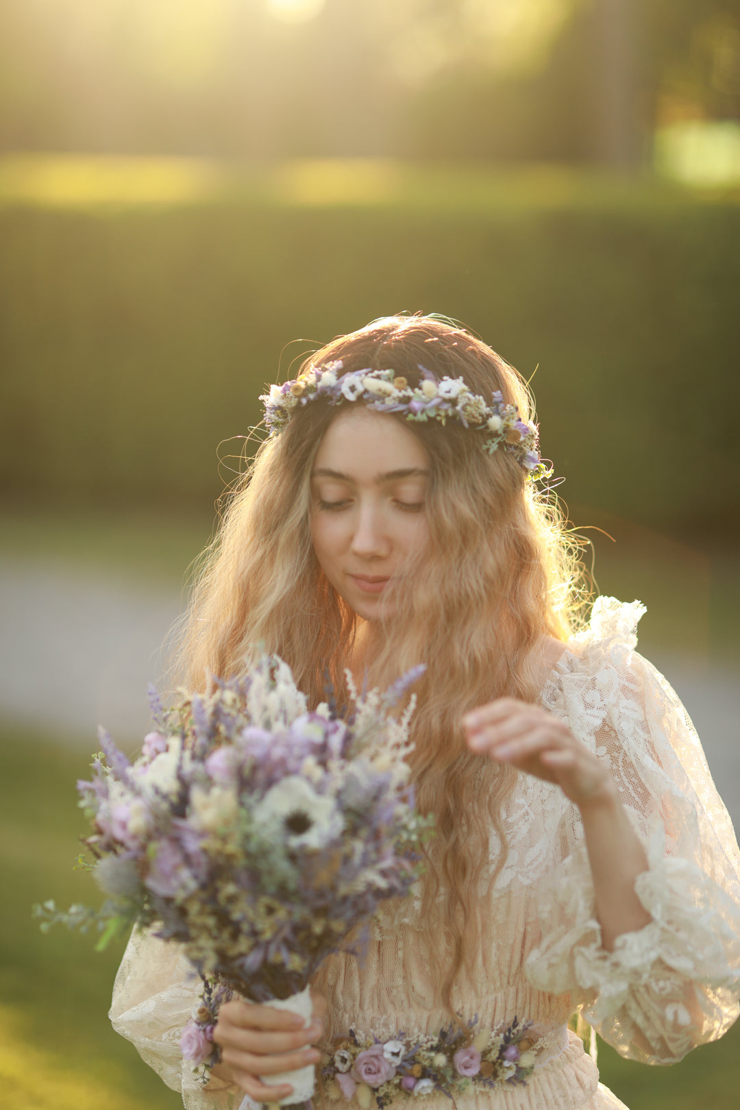 Woman holding a bouquet of purple and white flowers with a blurred natural background