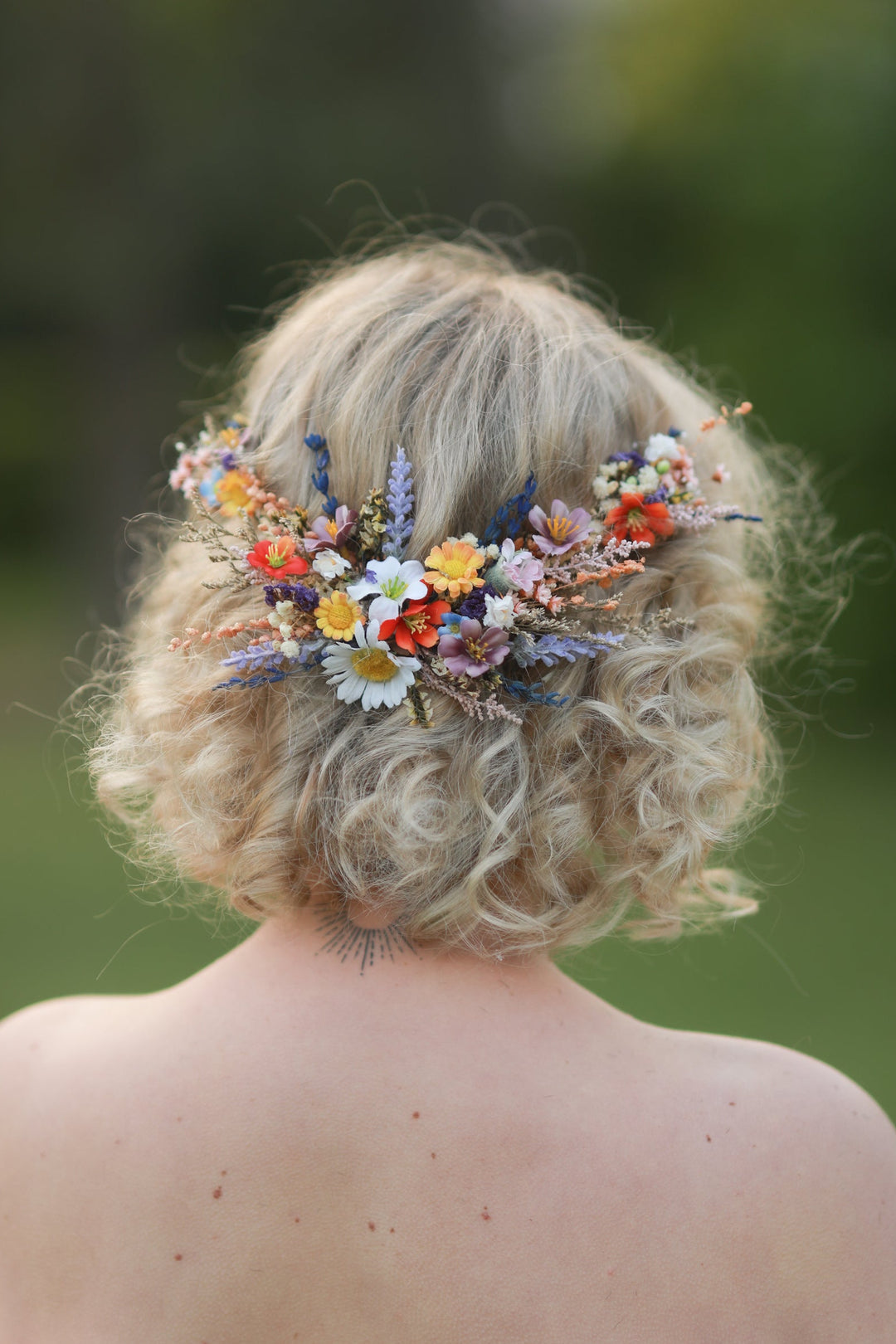 Person with floral hairpiece against a blurred natural background