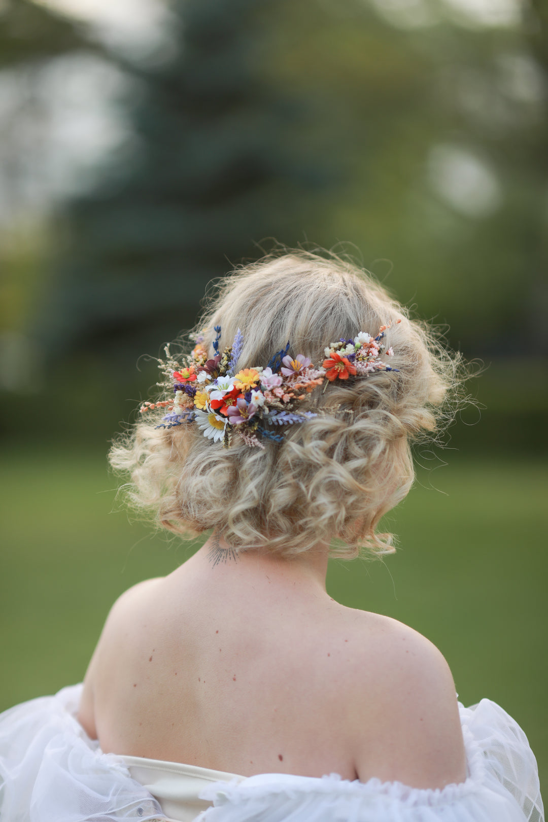 Person with floral hairpiece in a natural setting