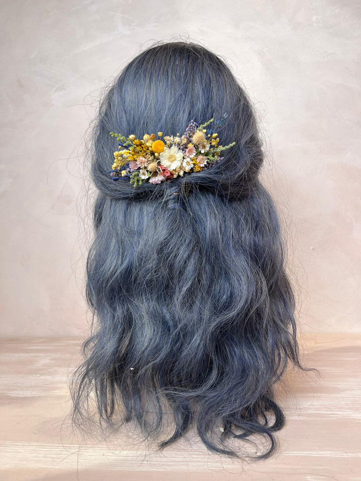 Blue hair with floral hairpiece on a neutral background