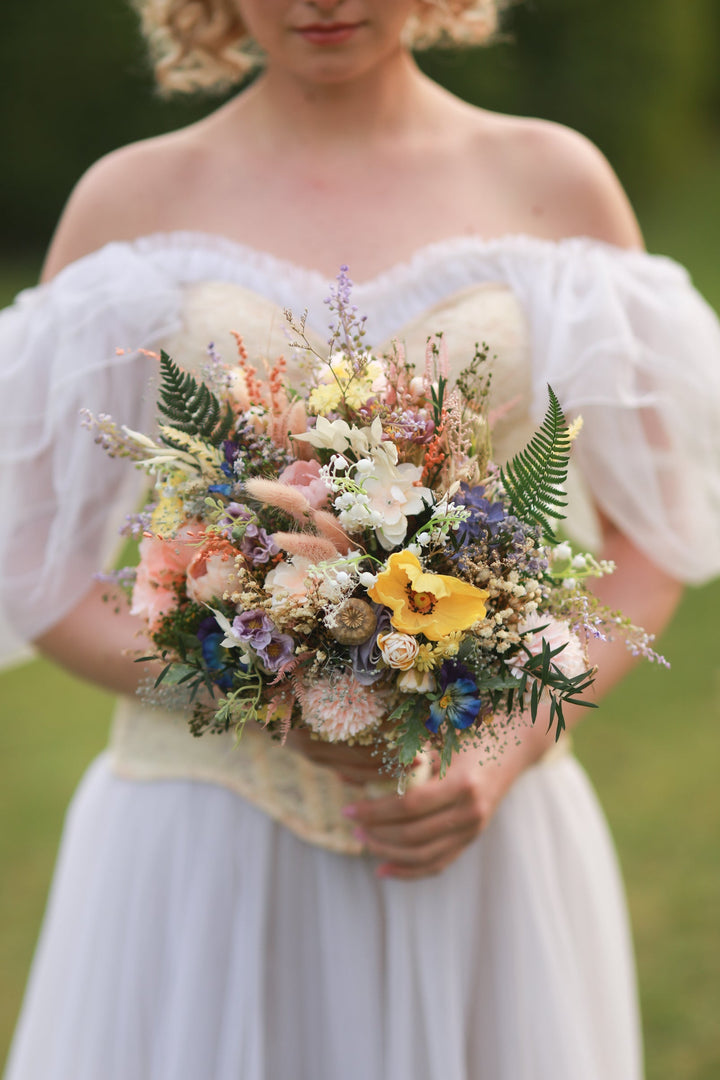 Woman in a white dress holding a bouquet of flowers in a natural setting