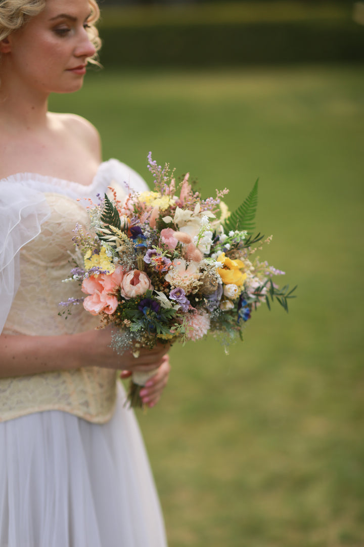 Woman holding a bouquet of flowers in a natural setting